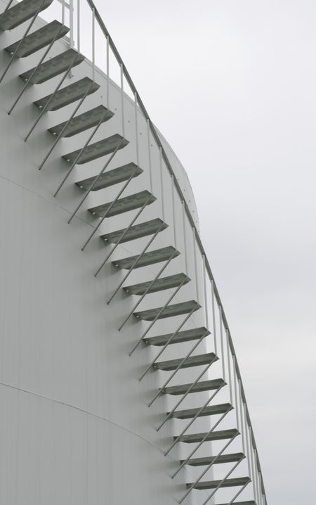 Curved stairway on exterior of refinery storage tank