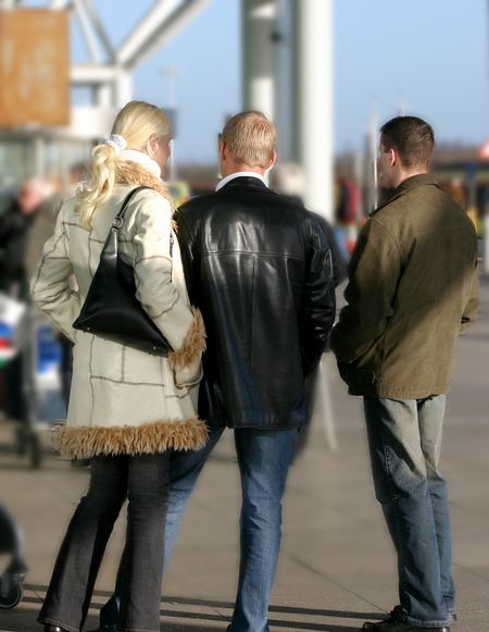 3 people waiting outside an airport in London