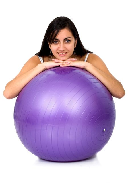 girl smiling leaning over a pilates ball - isolated over a white background