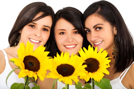 Beautiful female friends holding sunflowers and smiling over a white background