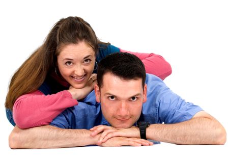 Casual couple lying on the floor smiling - isolated over white