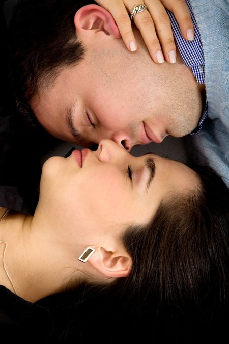 Casual couple lying on the floor with their eyes closed