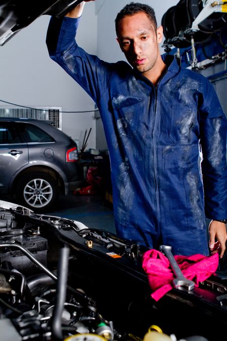 Mechanic fixing poping the hood of a car at the garage