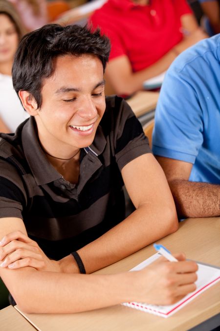 Man at university studying in a classroom and smiling