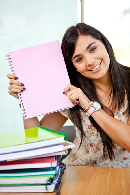 Happy female student with notebooks at the university