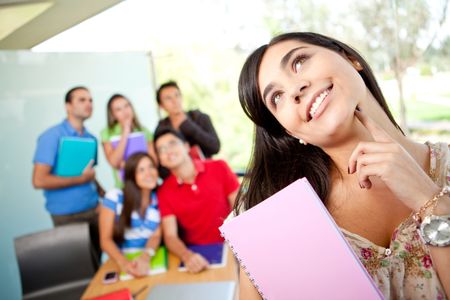 Thoughtful female student at the university with a group of people behind