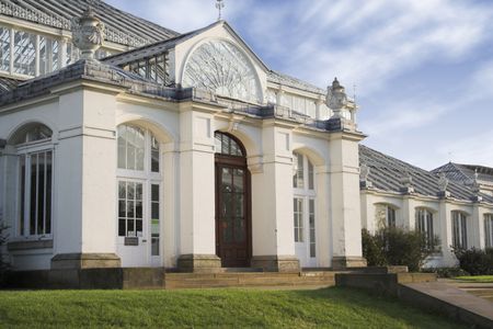 entrance of a white mansion with the sky at the background