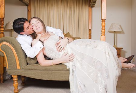 bride and groom on a sofa kissing