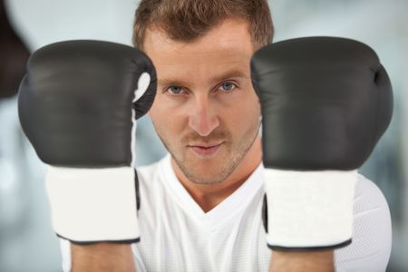 Male boxer wearing boxing gloves at the gym