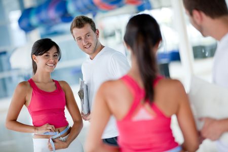 Woman at the gym with her trainer measuring her body