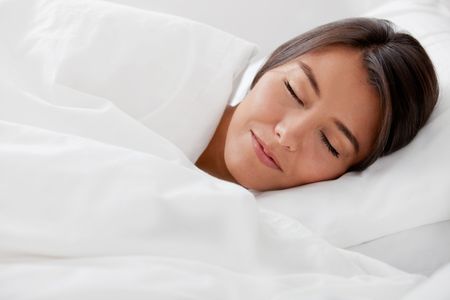 Beautiful woman sleeping in her white bed