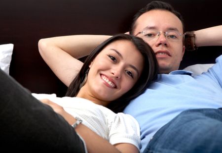 couple relaxing at home on their bed
