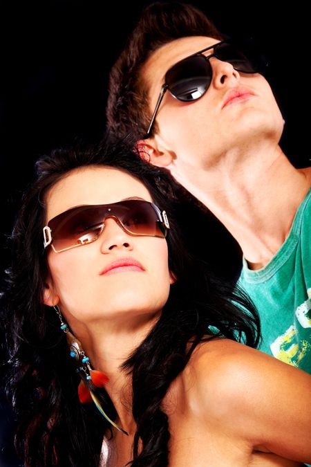 fashionable couple wearing sunglasses looking up
