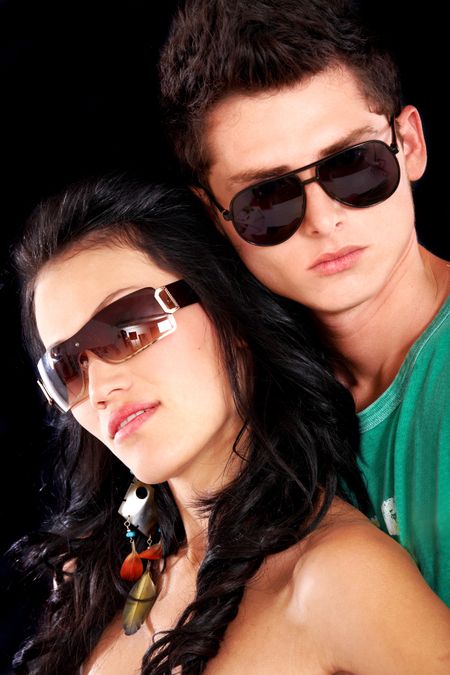 fashionable couple wearing sunglasses over a black background