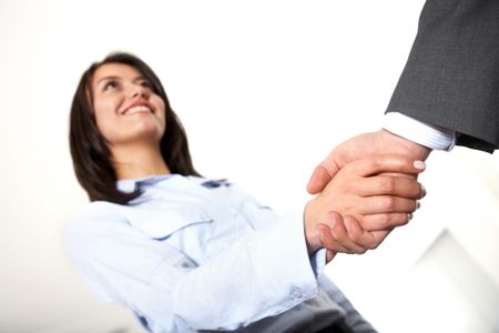 handshake to seal a business deal in an office - focus is on the hands