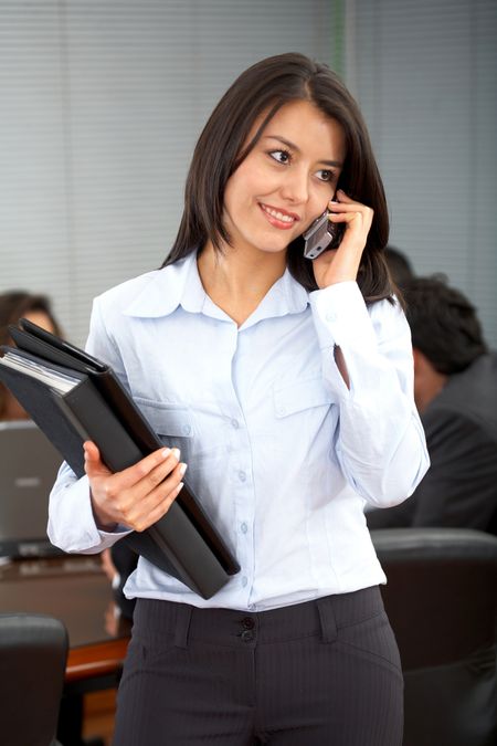 business woman on the phone smiling in an office