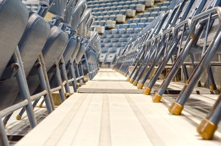 Legroom for many fans: Aisle between rows of folding chairs in sport and event arena (shallow depth of field)