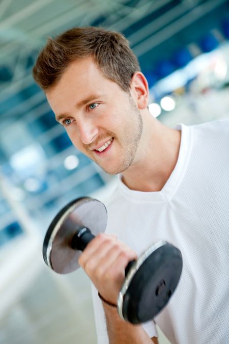Handsome man lifting free weights at the gym