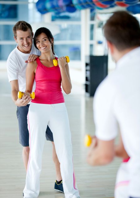 Beautiful woman exercising at the gym with her trainer