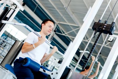 man at the gym exercising on a machine with weight