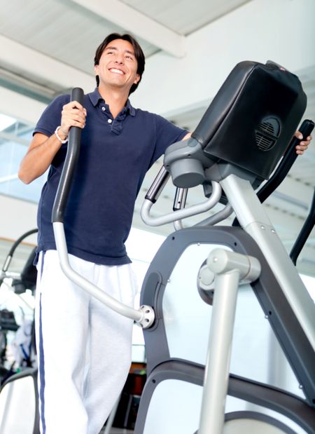 Man exercising at the gym in a xtrainer
