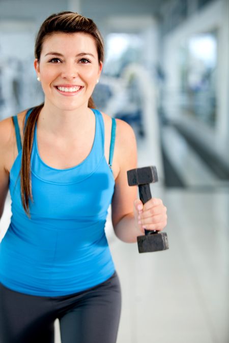 Beautiful woman at the gym exercising with free weights