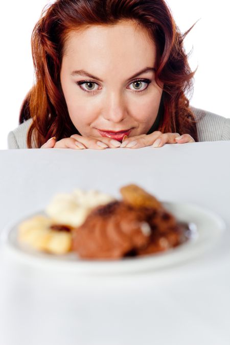 Woman having cravings and looking at food over the table