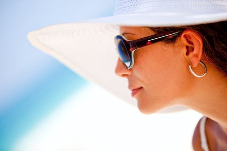 Summer woman looking at the horizon, wearing hat and sunglasses