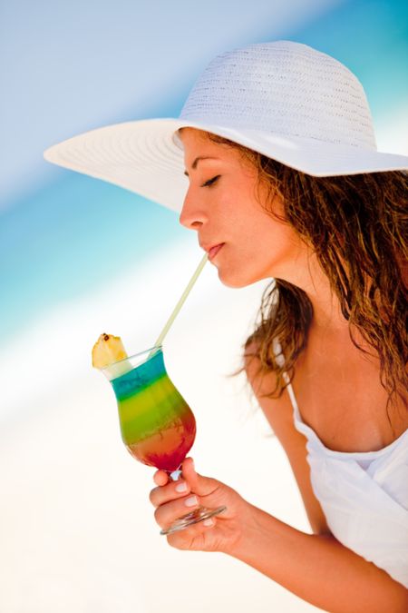 Woman at the beach drinking a refreshing beverage