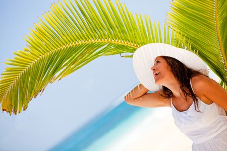 Delighted woman at the beach enjoying her holidays and smiling