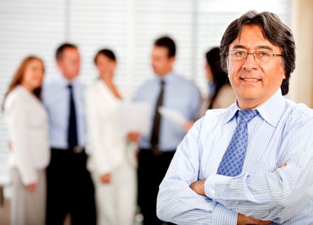 Business man at the office with his team on the background