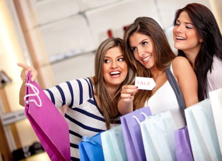 Happy group of females shopping on sale and smiling