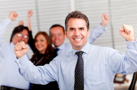 Happy man with arms up leading a successful business group