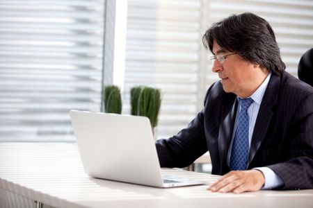 Successful male worker at the office with a laptop