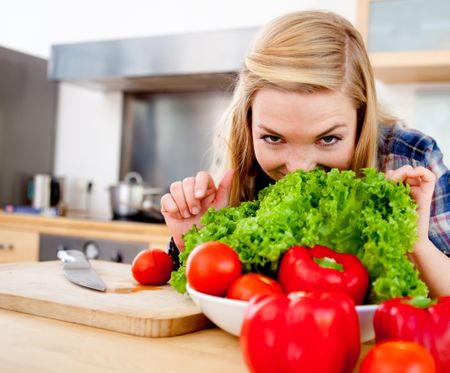 Healthy eating girl making a fresh vegetable salad