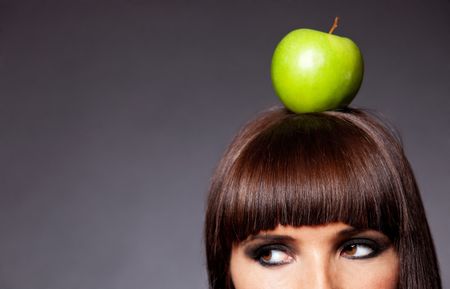 Woman thinking organic with an apple on her head