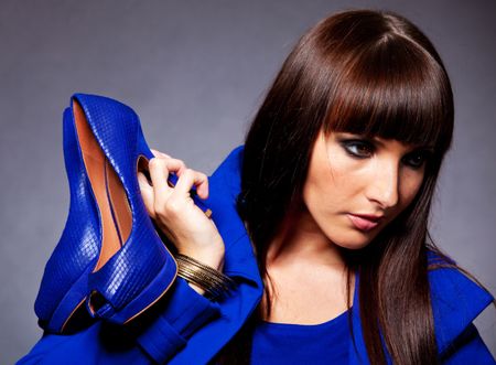 Portrait of a fashion woman holding elegant shoes