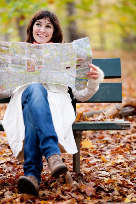 Lost woman looking for directions in a map â?? outdoors