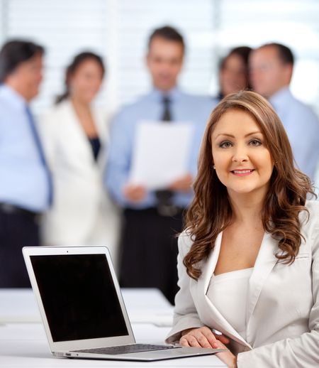 Business woman with a group at the background - indoors