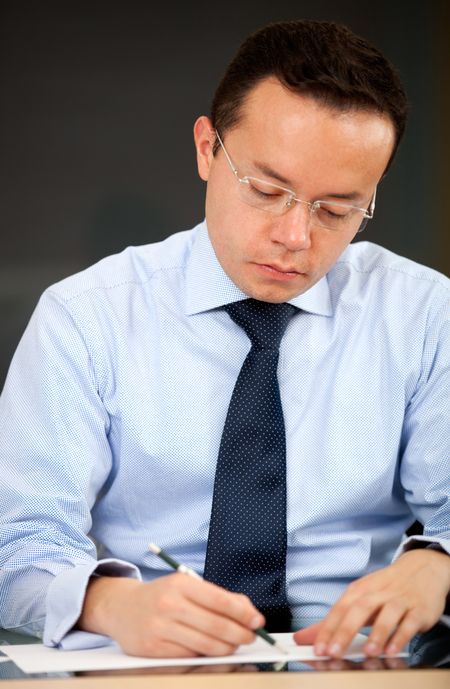 Male teacher grading exams at the school