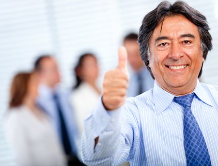 Positive business man with thumbs-up at the office