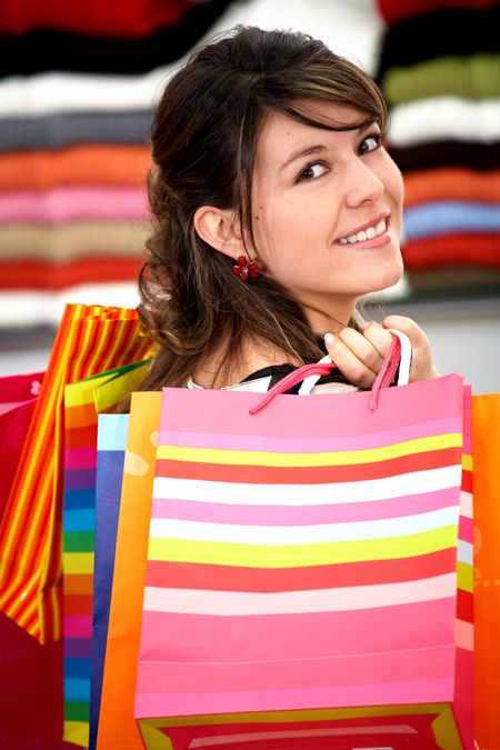 girl in a retail store smiling and carrying shopping bags
