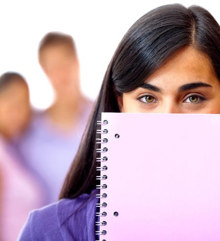Female student covering her face wih a notebook - isolated over a white background