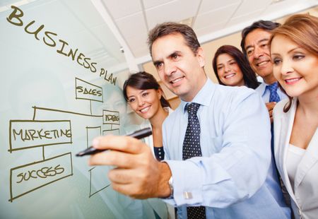 Corporate group drawing a business plan on the board