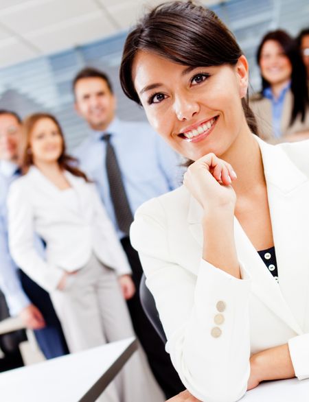 confident-corporate-female-worker-group-background-89506330 Confident corporate female worker with a group at the background