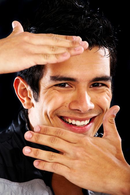 casual man portrait smiling and framing his face over a black background