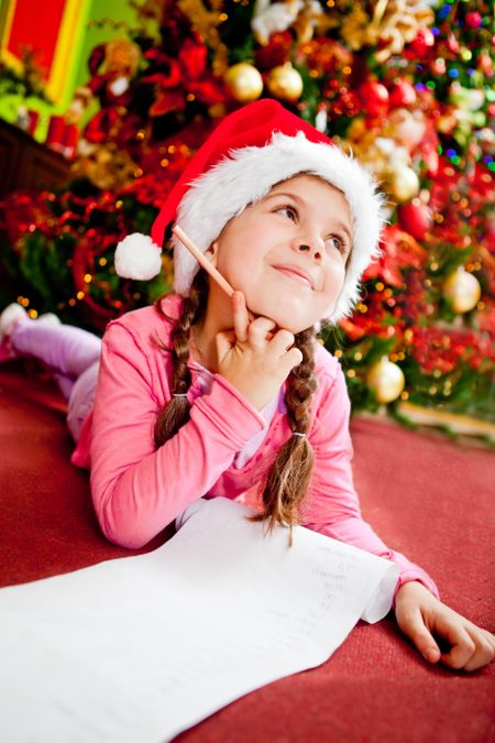Girl writing a letter to Santa with her Christmas wishes