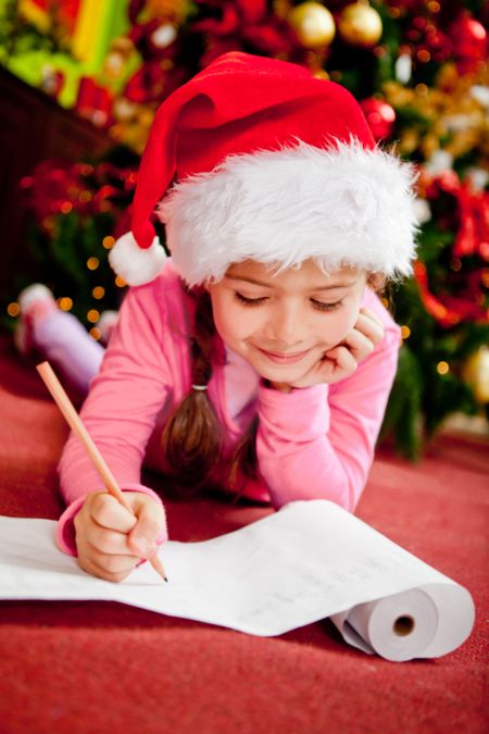 Girl writing a Christmas wish list for Santa