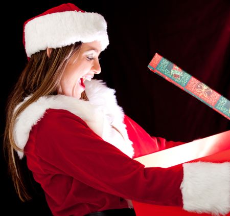 Female Santa opening a Christmas present and looking surprised