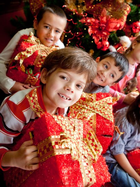 Group of happy kids holding Christmas presents and smiling